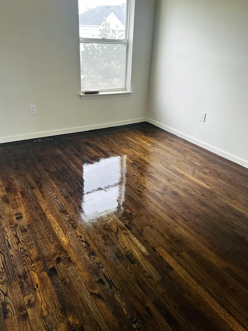 Bedroom with a dark walnut-tone stained hardwood floor after refinishing