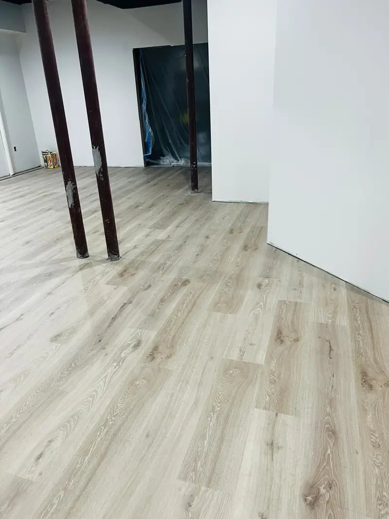 Basement vinyl plank floor installed around support columns