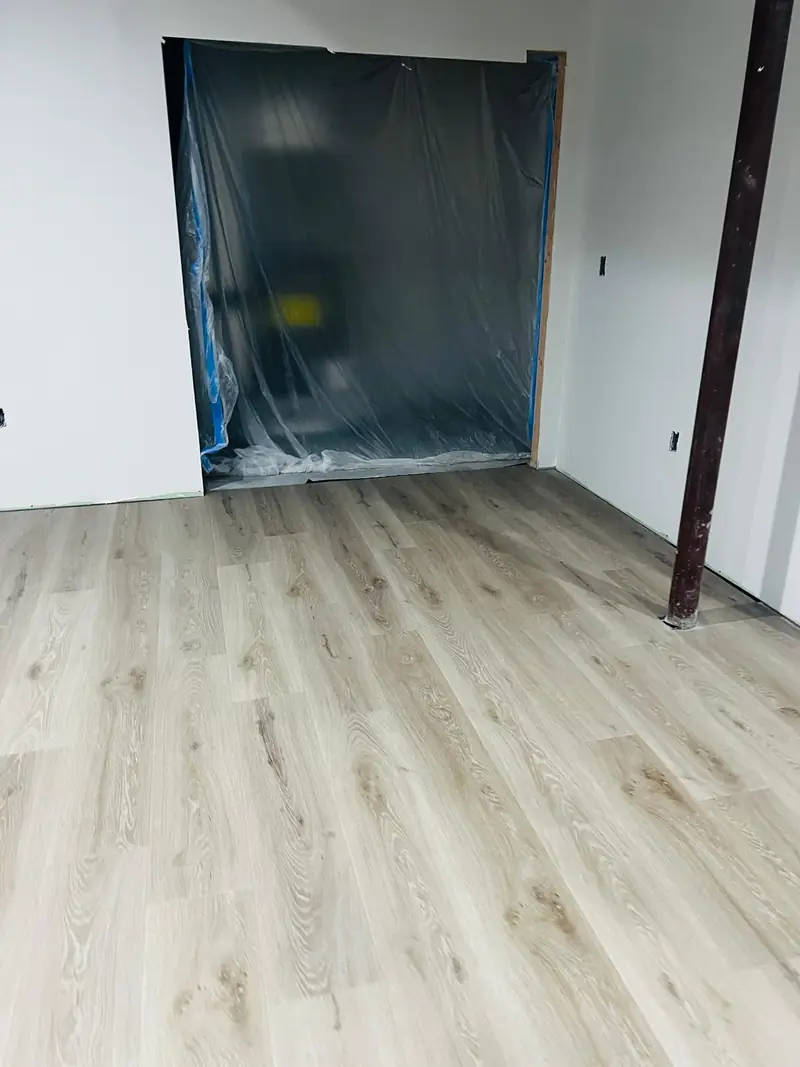 Light-colored vinyl flooring installed in a basement room