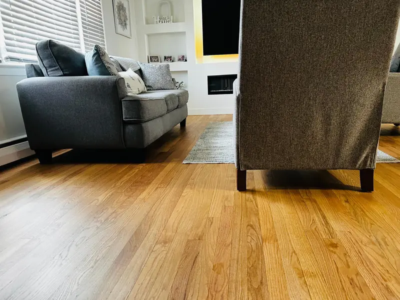 Living room hardwood floor refinished with a natural-tone stain and water-based finish